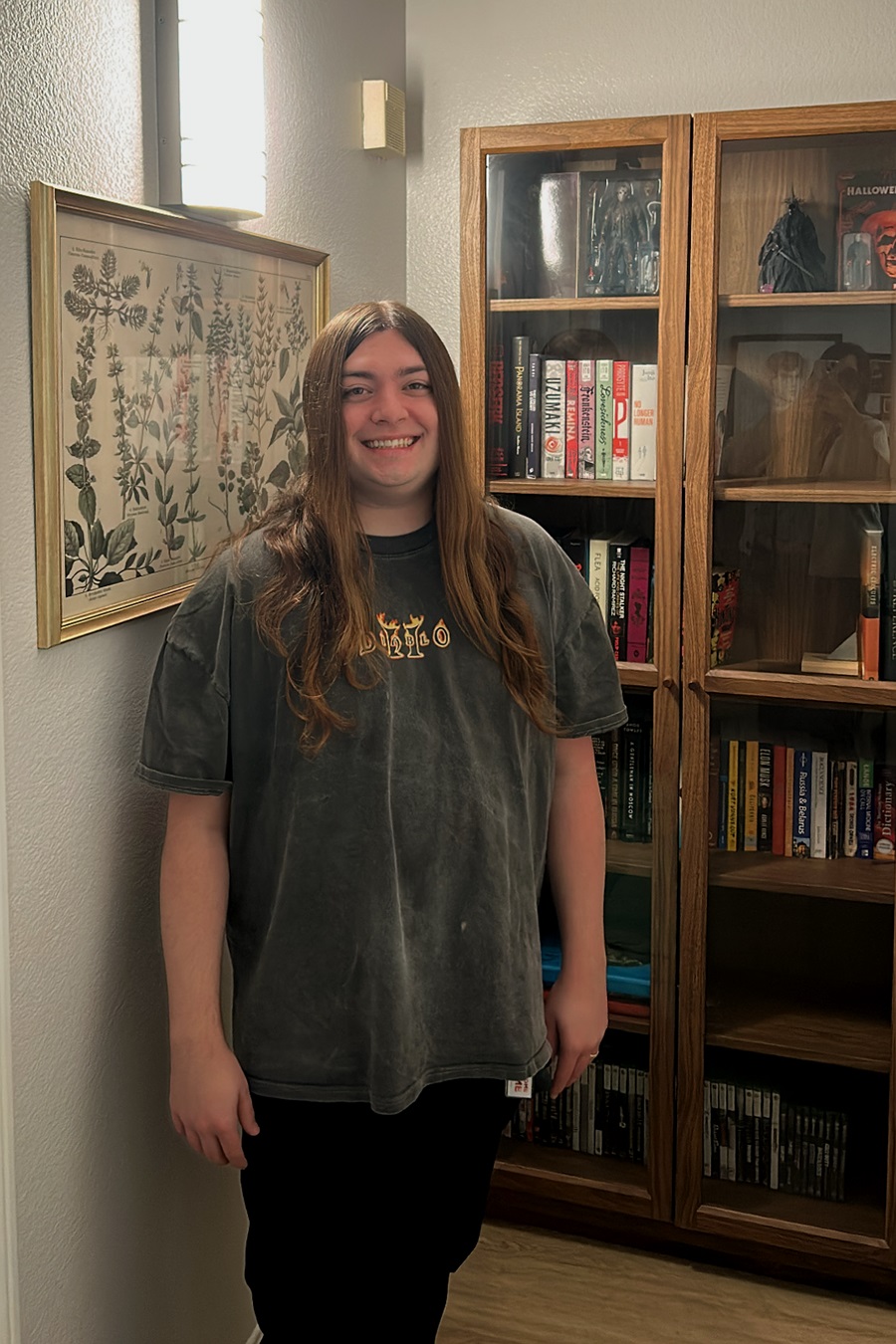 Portrait of Marty Lange standing beside a wooden bookcase